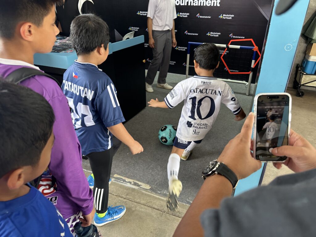 A young athlete tries the Bitget booth's game to win freebies